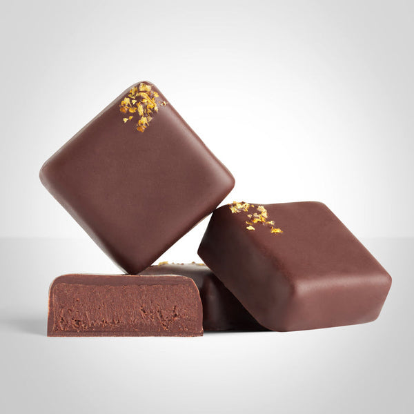 2 bonbons ganache agrumes et un bonbon coupé en deux