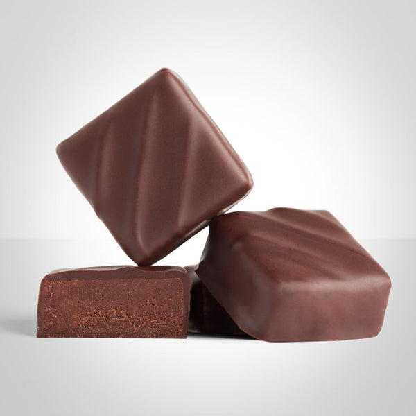 2 bonbons ganache chocolat pure origine du moment et un bonbon coupé en deux