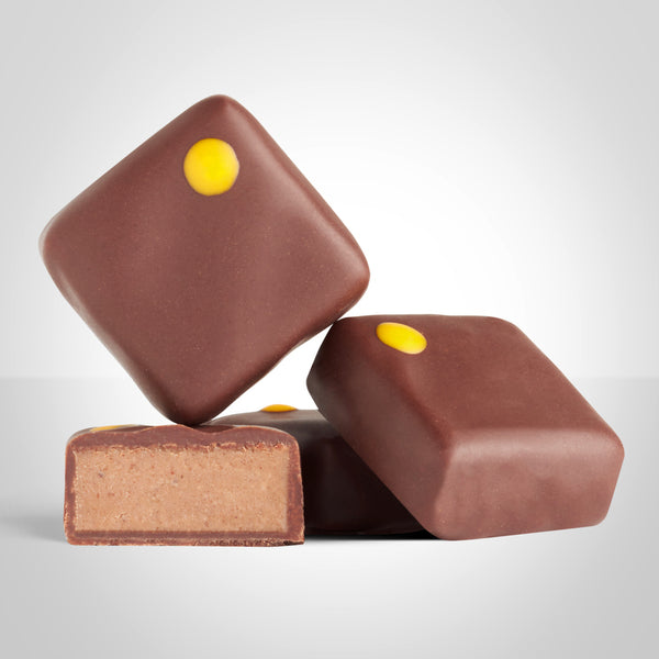 Bonbons praliné gianduja en chocolat au lait de L'Instant Cacao et bonbon coupé en deux