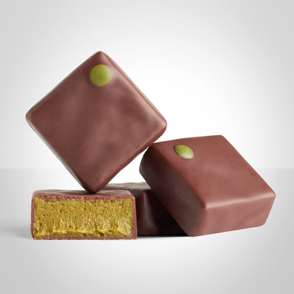 Bonbons praliné thé matcha en chocolat au lait de L'Instant Cacao et bonbon coupé en deux