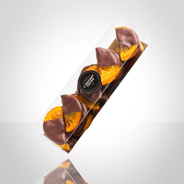 Boite de demi tranches d'oranges confites trempées en partie dans du chocolat noir