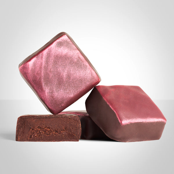 2 bonbons ganache framboises  de L'Instant Cacao et un bonbon coupé en deux