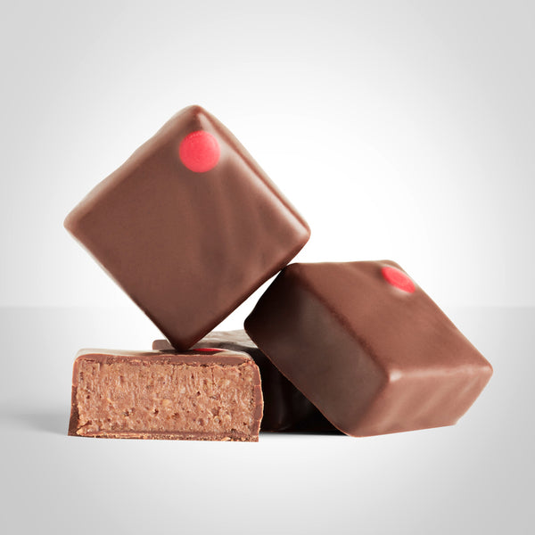 Bonbons praliné arachide en chocolat au lait de L'Instant Cacao et bonbon coupé en deux