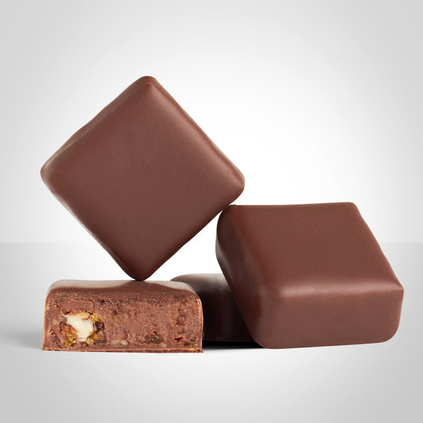 Bonbons praliné noix de pécan en chocolat au lait de L'Instant Cacao et bonbon coupé en deux